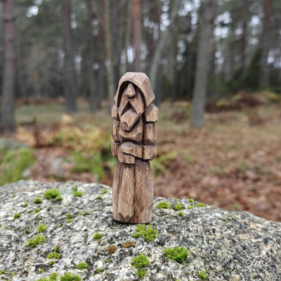 Täljd figur på en sten i skogen